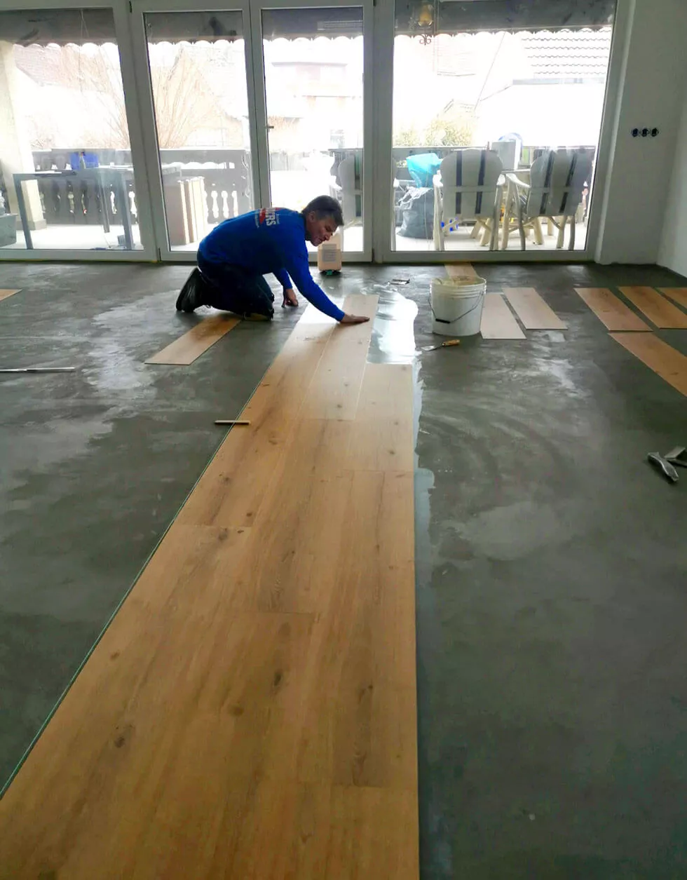 Geschäftsführer Michael Enders verlegt Parkett in einer Wohnung